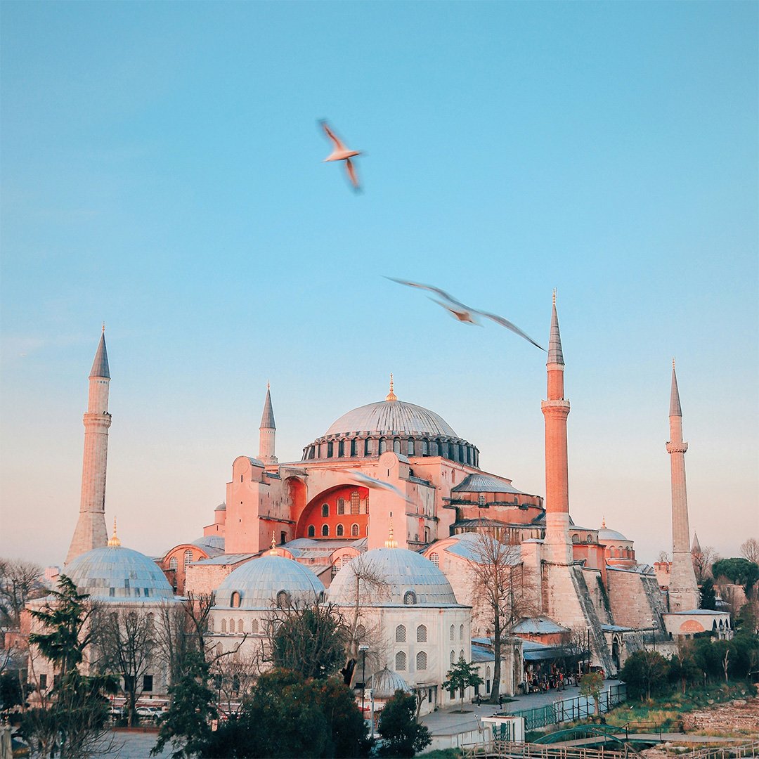 Hagia Sophia in Istanbul, Turkey, with seagulls flying above at sunset
