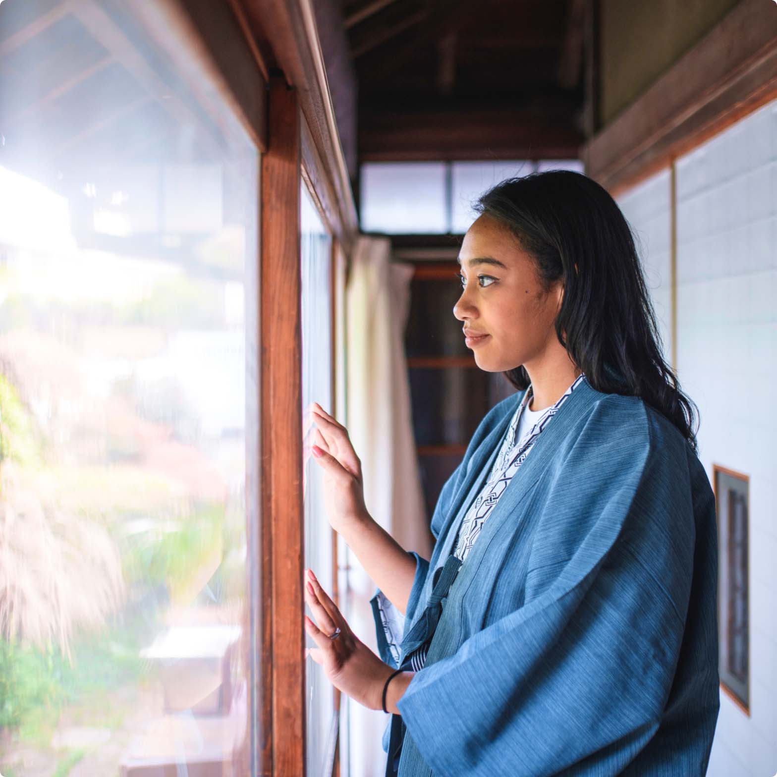 Woman looking out the window of a Japanese style home