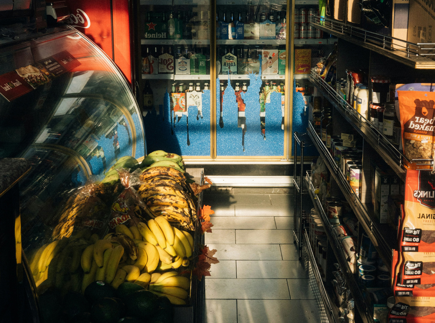 Bananas and fresh produce inside a small convenience store, with drinks and snacks on display. Bananas and fresh produce inside a small convenience store, with drinks and snacks on display.